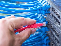 Business Phone Technician connecting patch lead to patch panel